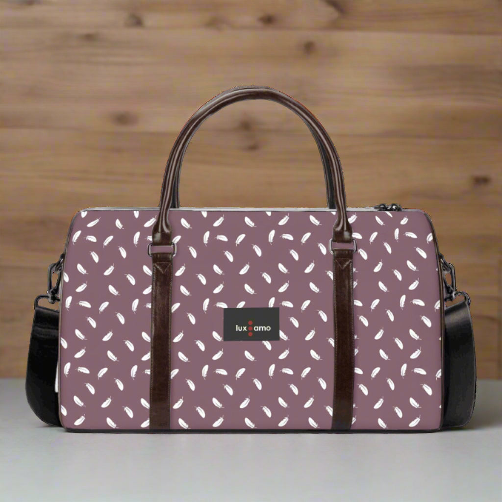 Purple duffel bag with white pattern and brown handles on a white background