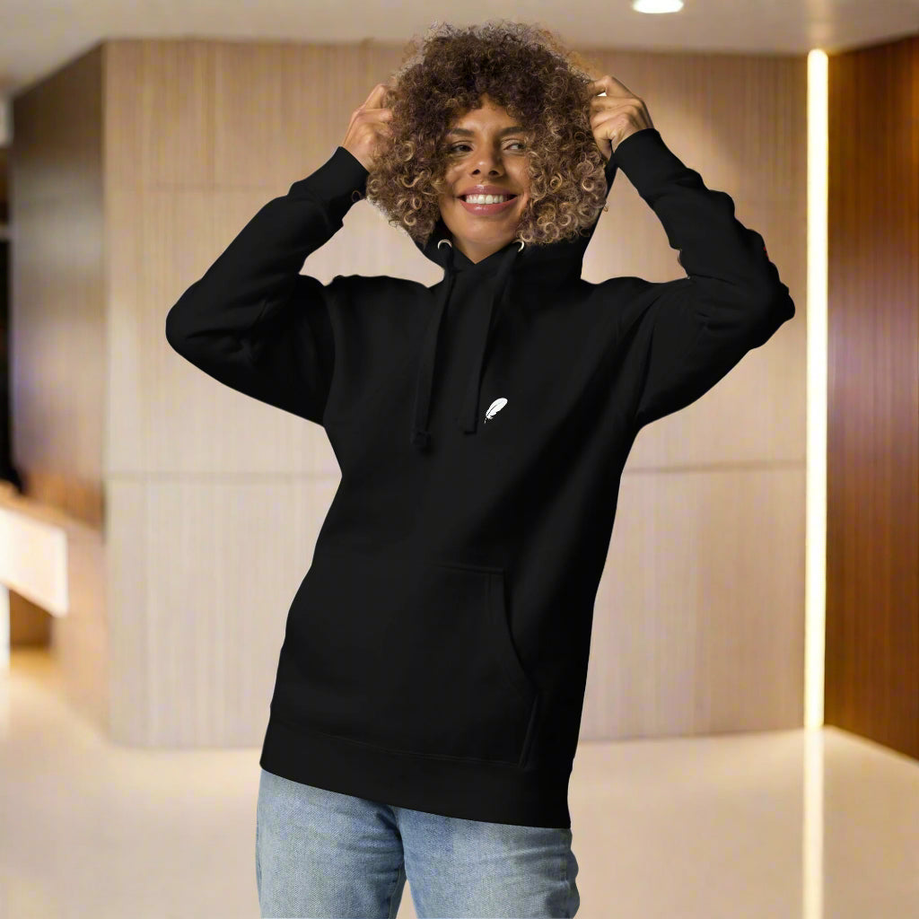 Person wearing a black hoodie with a white logo