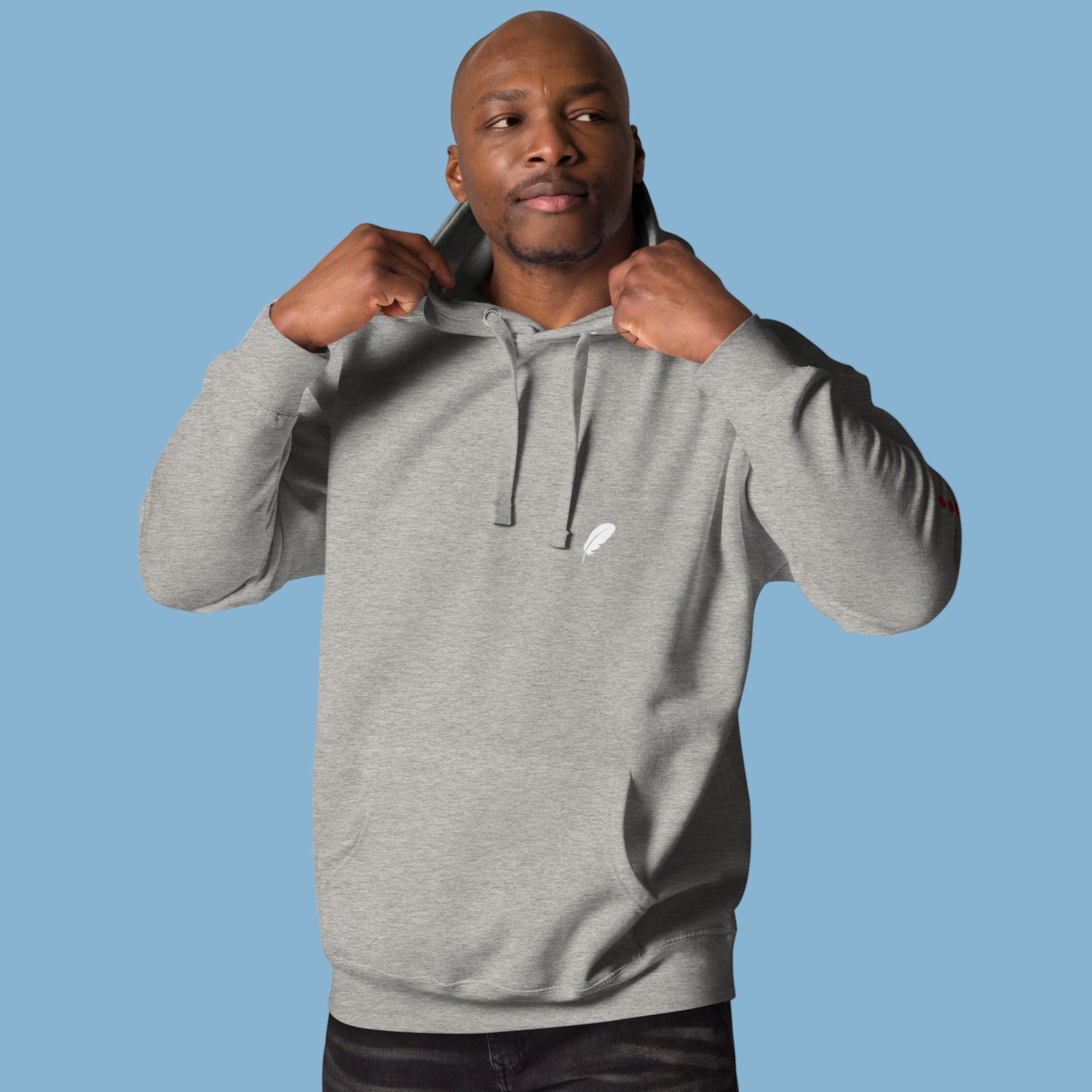 Man wearing a grey hoodie with a small white logo