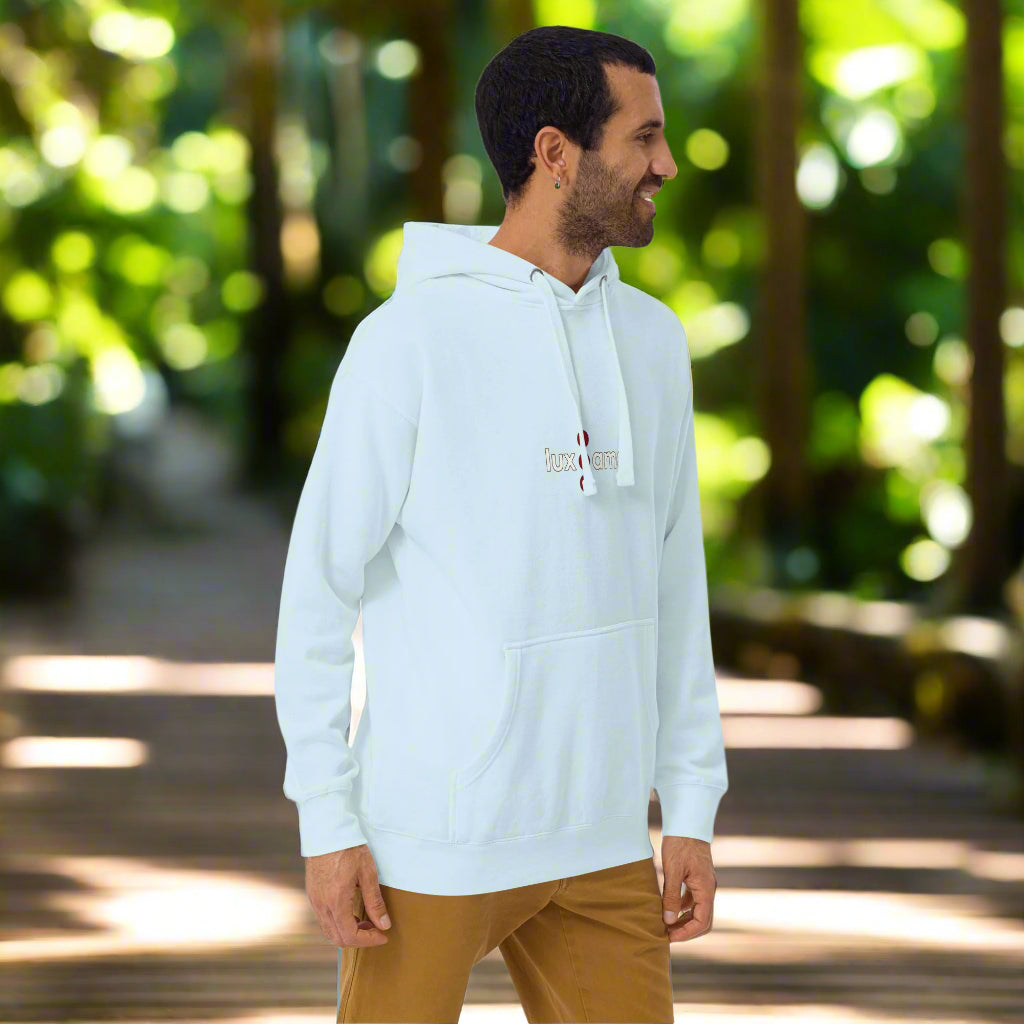 Man wearing a light blue hoodie with a logo in woodland