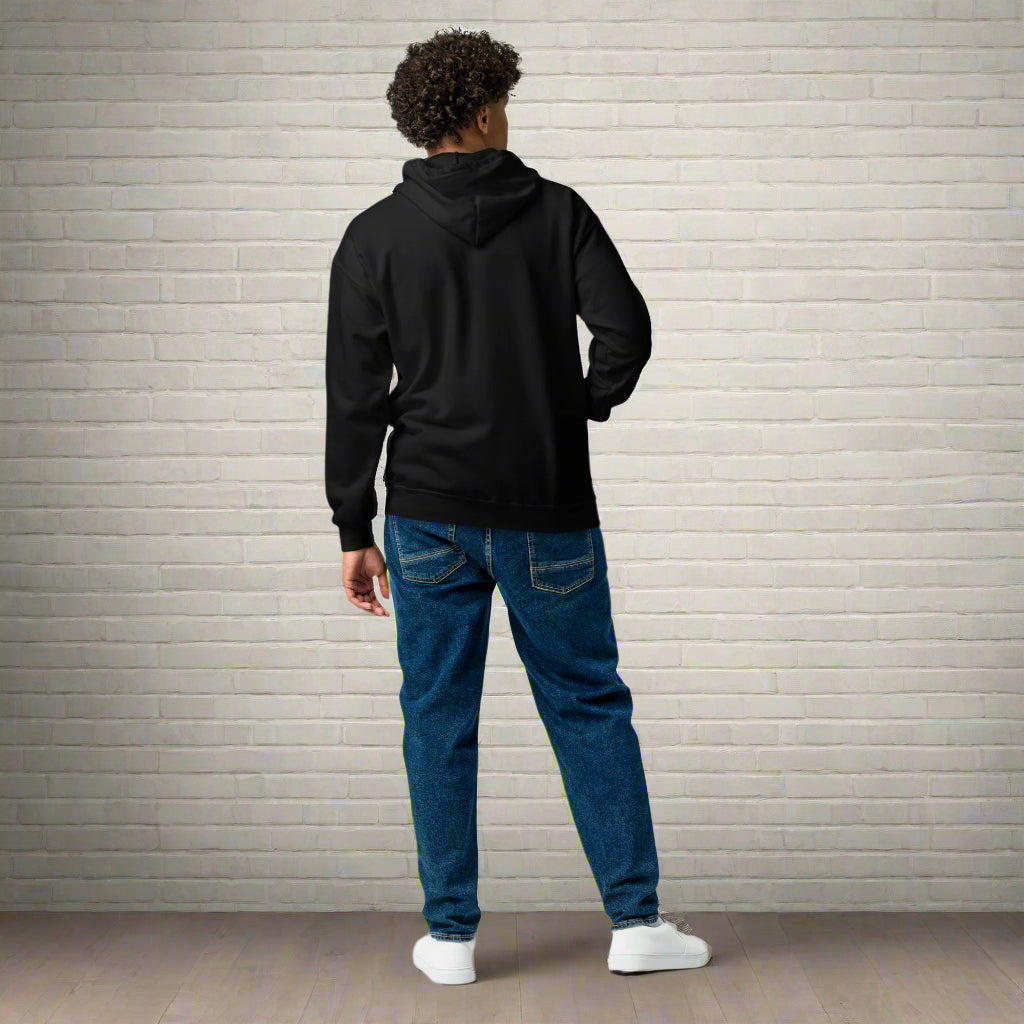 Person wearing a black hoodie and blue jeans on a white background