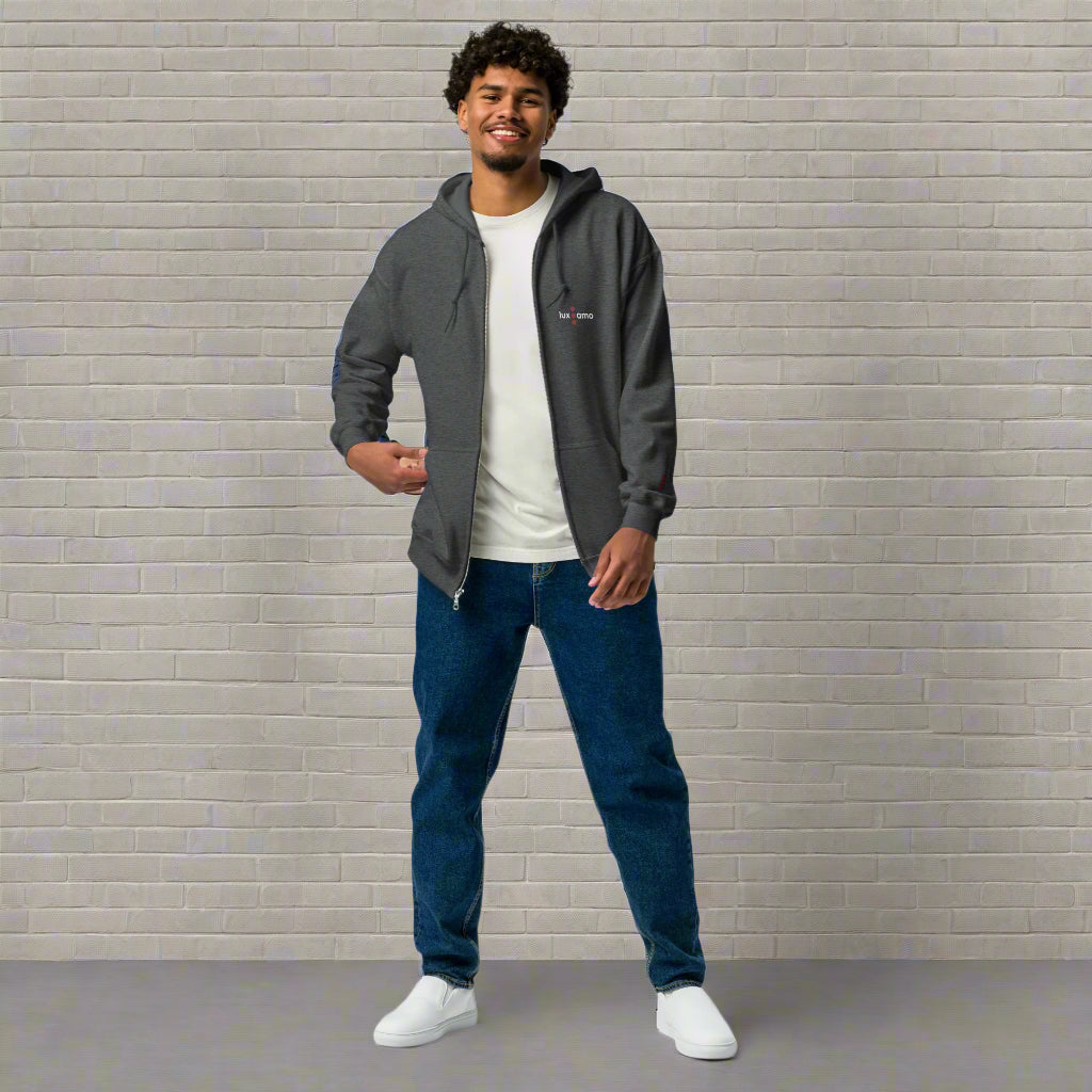Man wearing a gray hoodie, white t-shirt, blue jeans, and white sneakers on a white background