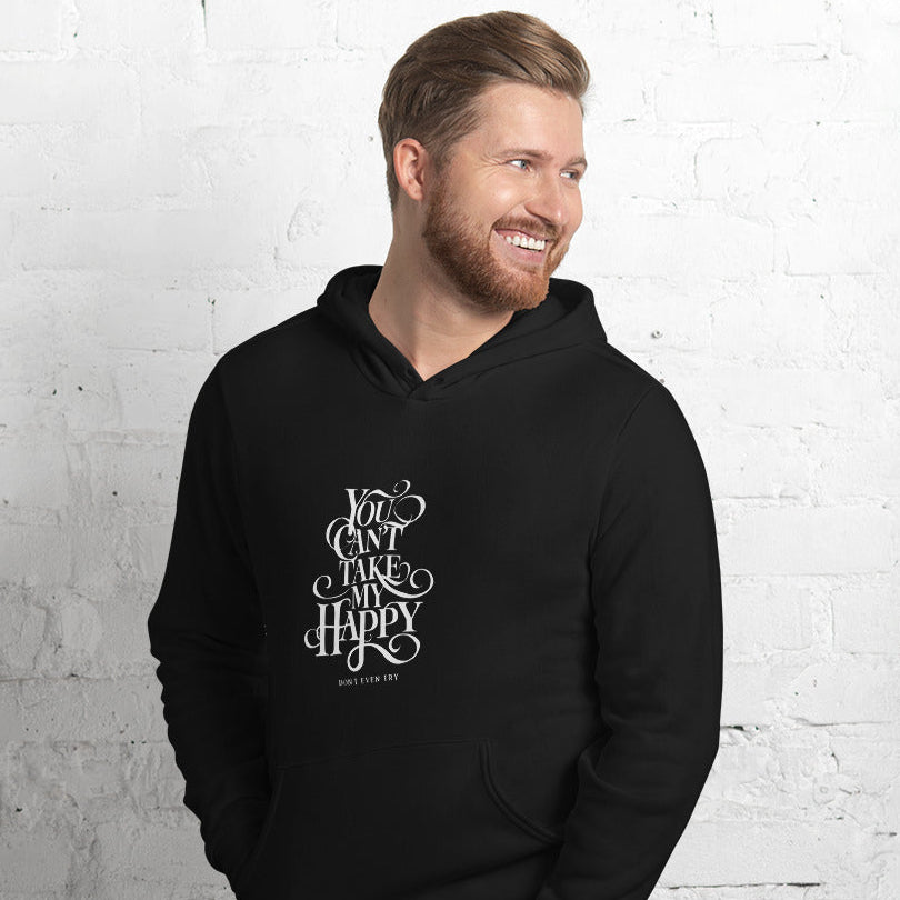 Man wearing a black hoodie with text against a white brick wall
