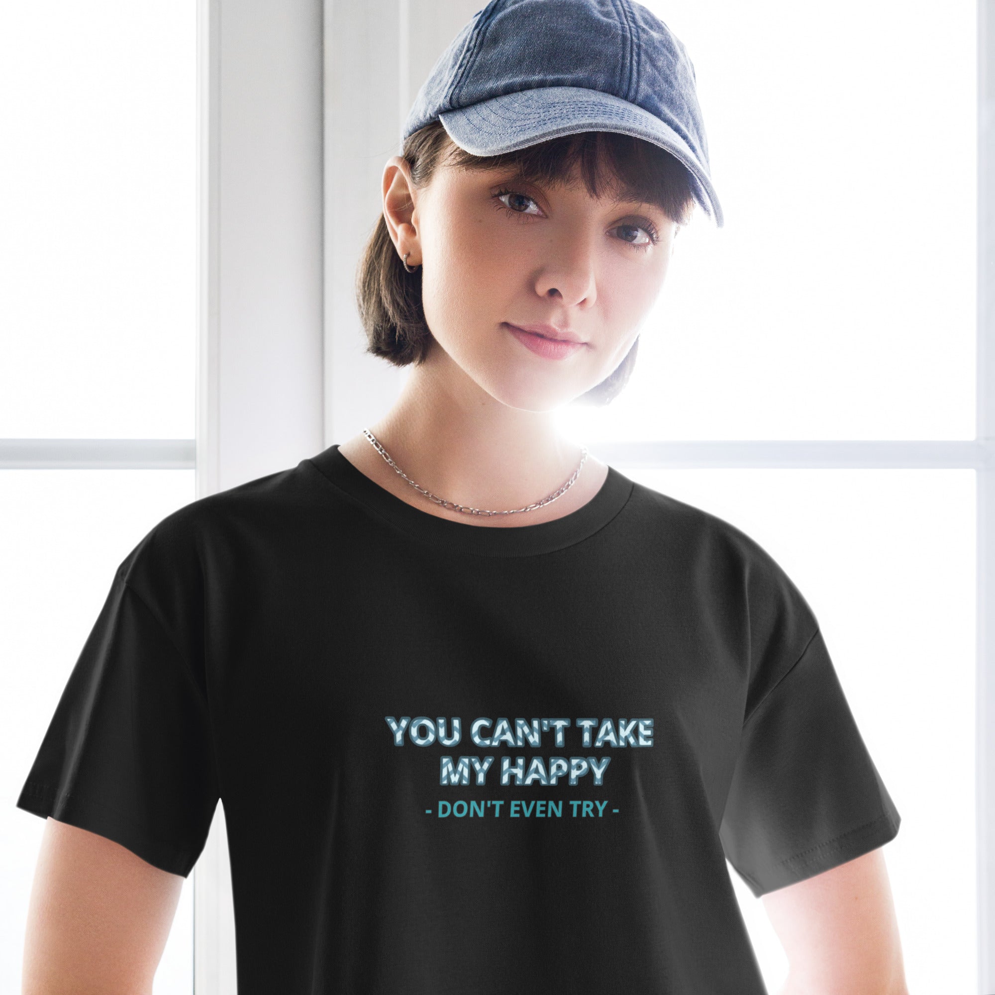 Person wearing a black t-shirt with a motivational quote, standing indoors.