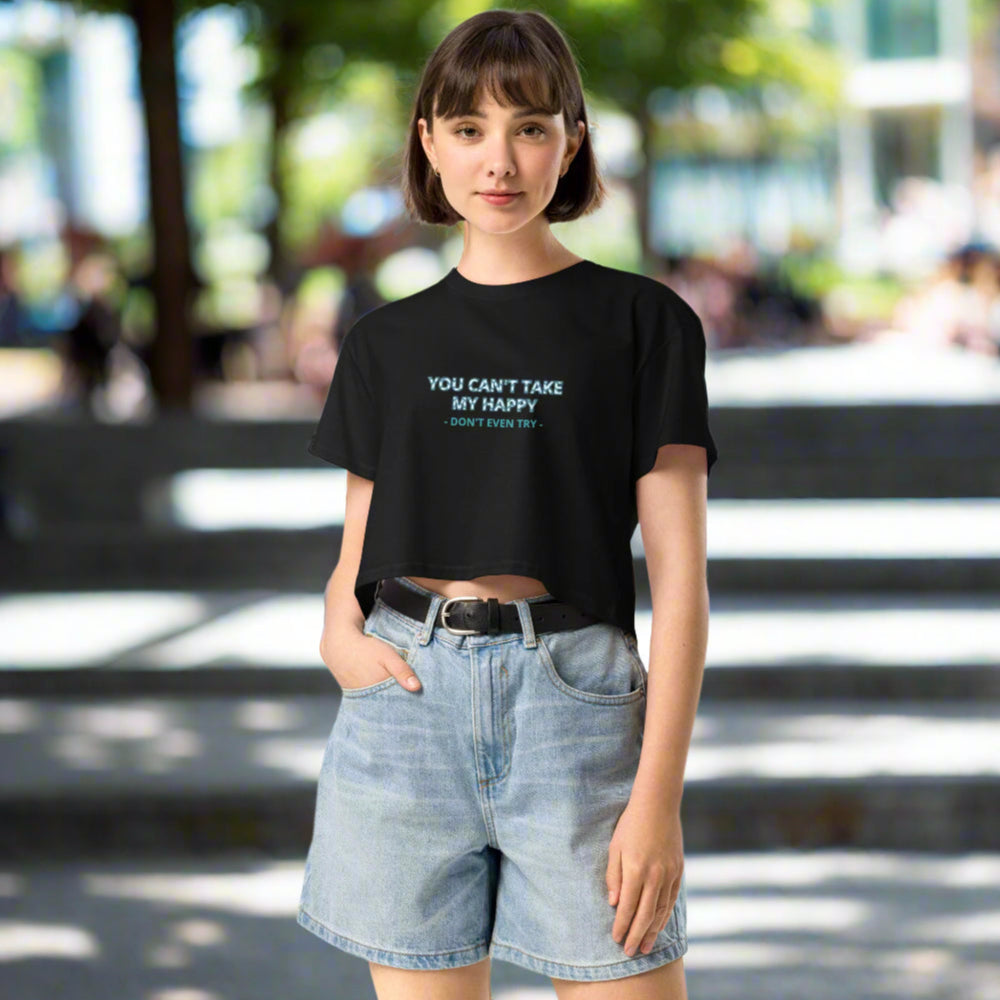 Person wearing a black t-shirt with text and denim shorts on a white background