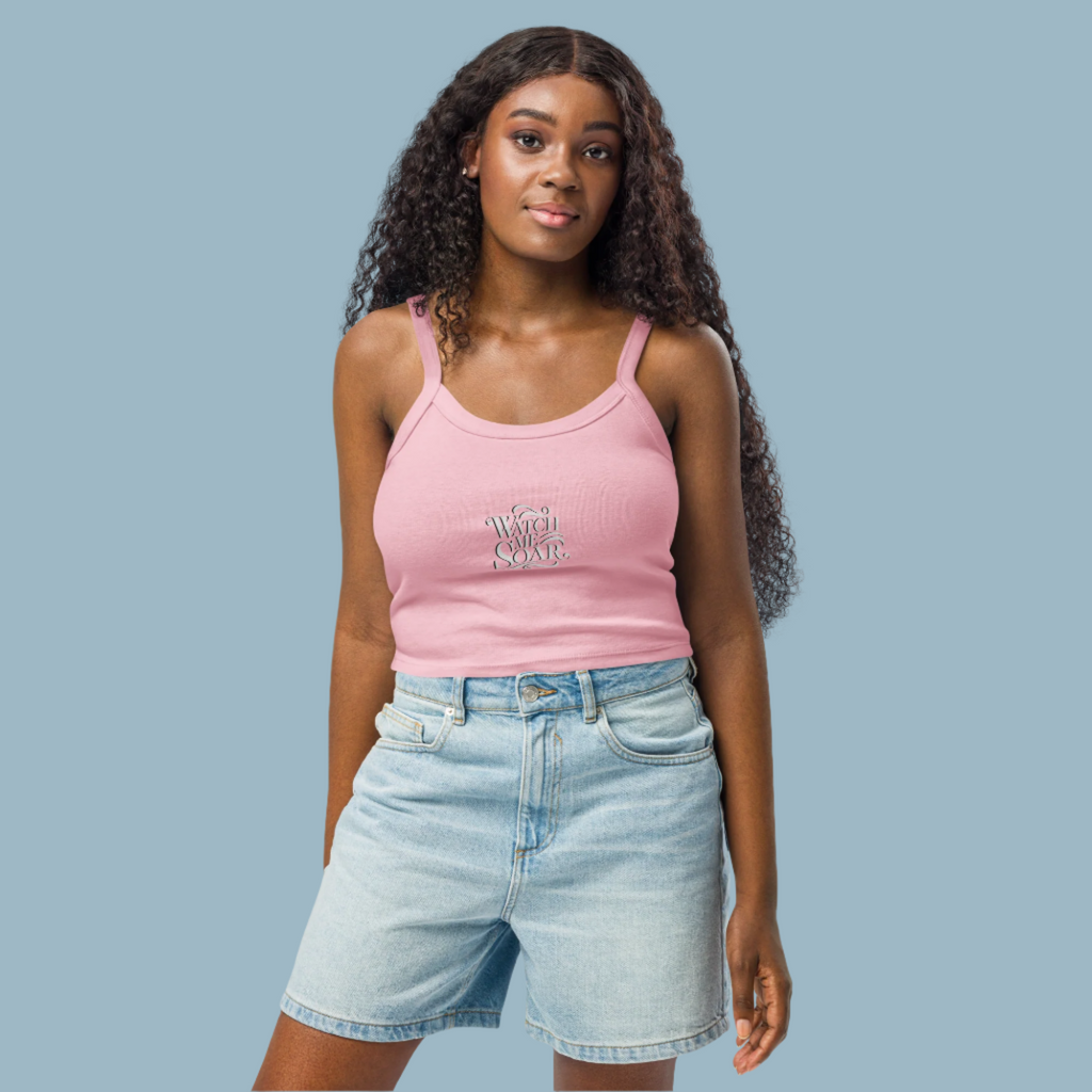 Woman wearing a pink tank top and denim shorts on a white background